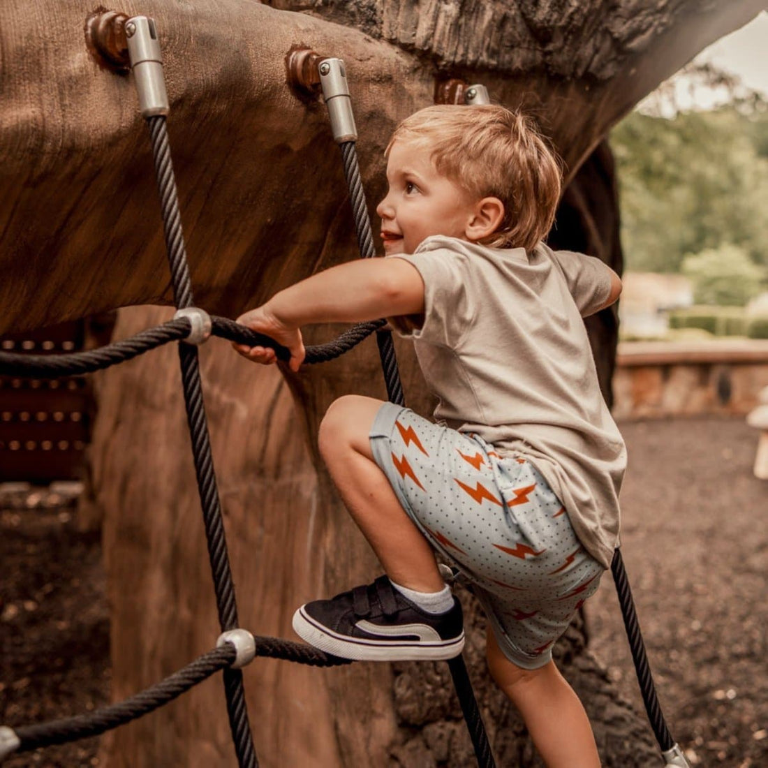 Toddler climbing in Spark Retro Shorts with Ocean Cubs Wear design.