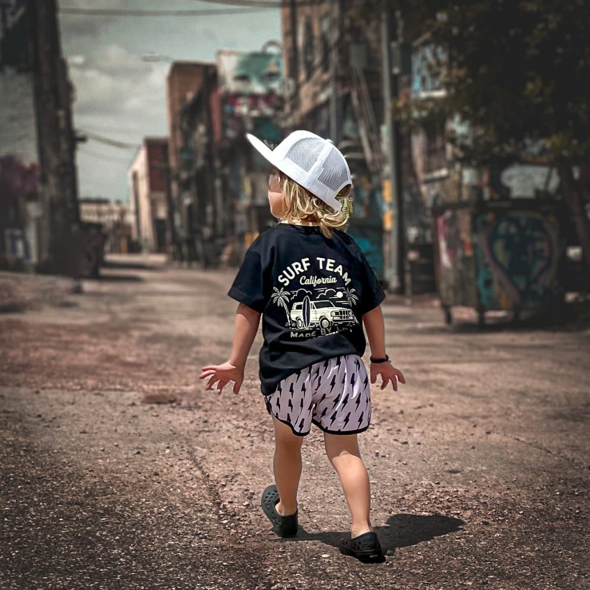 Child skateboarding in blue Surf Team tee and jeans.